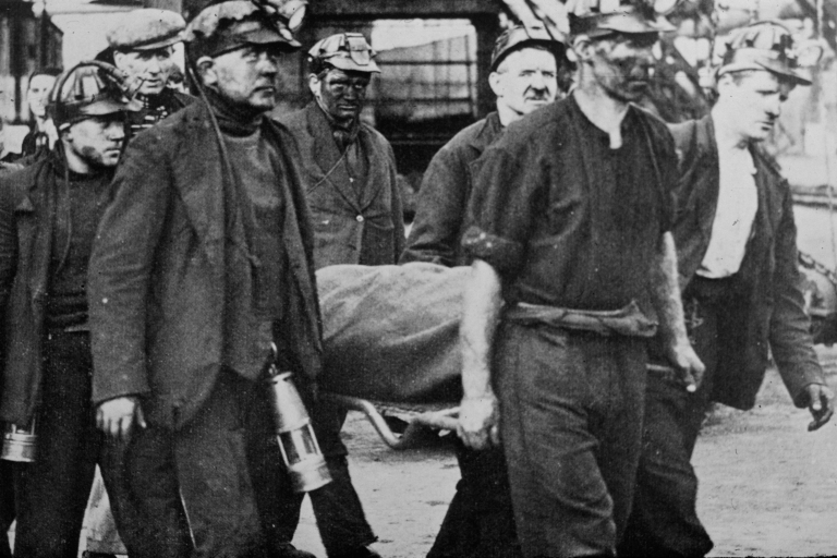 Coal miners carrying injured miner