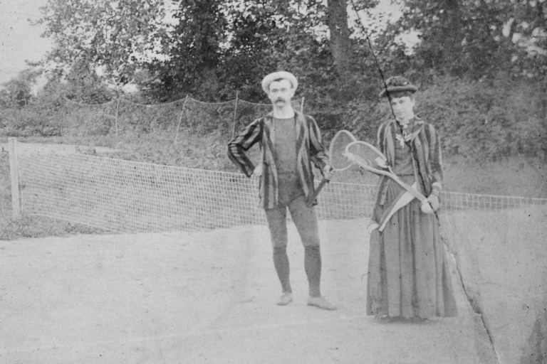 Two people posing with tennis rackets